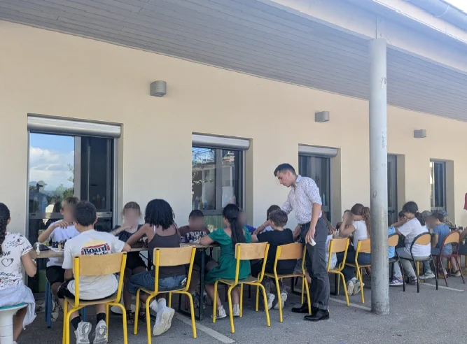 Valentin Chapron arbitre une compétition d'échecs entre enfants installée dans une cour d'école