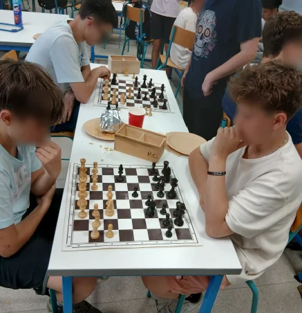 Deux collégiens concentrés sur leur partie pendant un atelier d'échecs en classe
